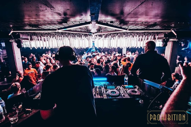 A packed club seen from behind the decks